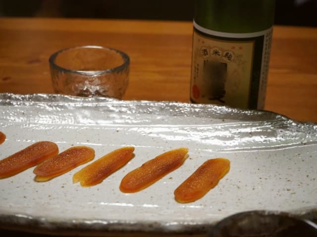 自家製ボラのカラスミと日本酒を楽しむ食卓の様子